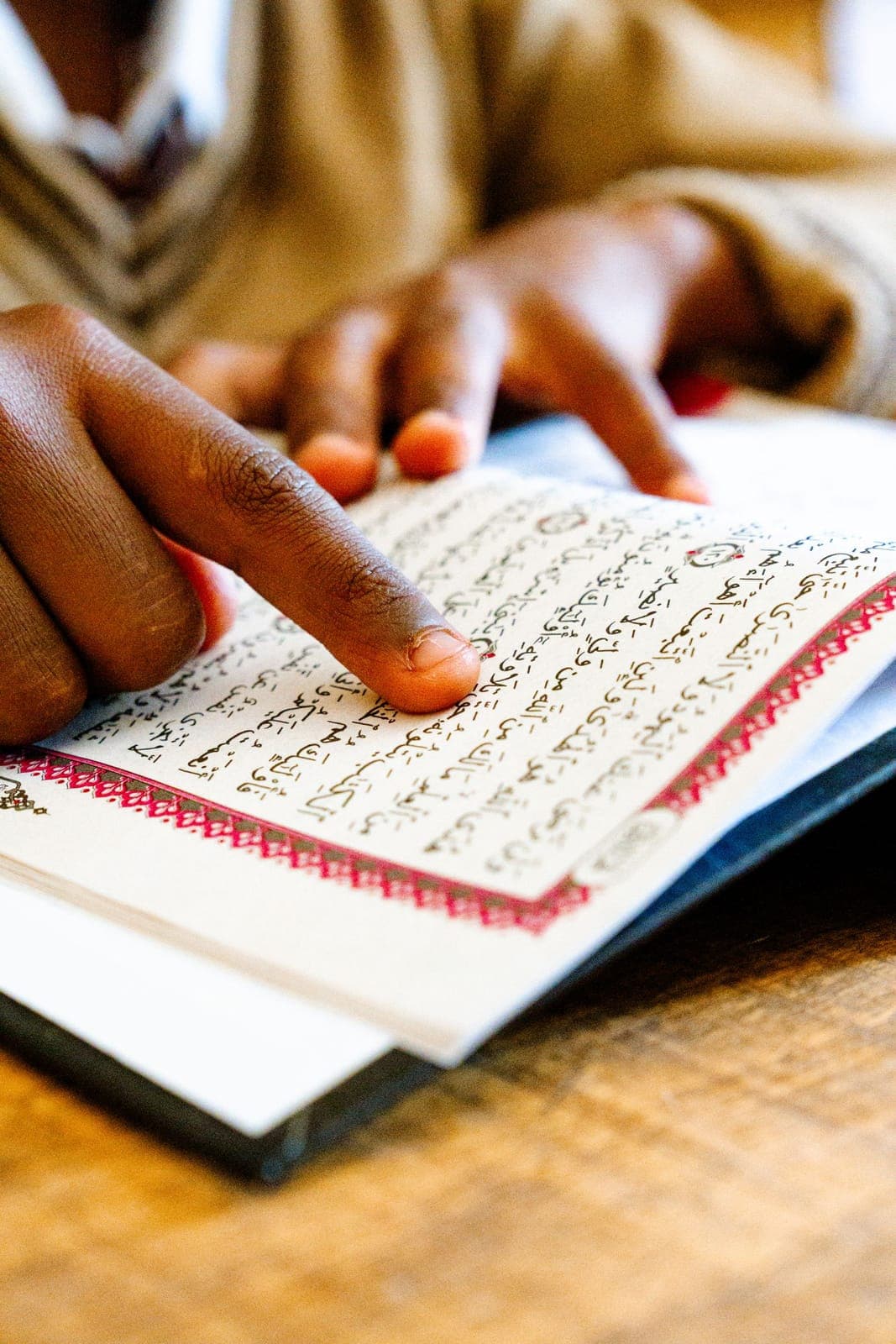 A child following a line of the Quran with a finger
